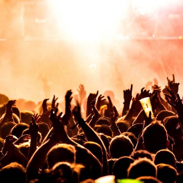 Quelle: Bild von Tijs van Leur auf unsplash Menschenmenge bei einem Konzert mit erhobenen Händen vor einer hell erleuchteten Bühne